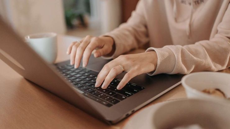 Женщина сидит за ноутбуком и проверяет свой кредитный рейтинг