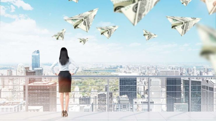 Девушка стоит на вершине небоскреба и видит летающие купюры денег – видеть деньги во сне имеет противоречивые значения