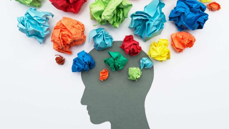 Galvas siluets, ap kuru saliktas krāsainas saburzītas lapiņas – emocijas, kas var ietekmēt mūsu finanšu lēmumus