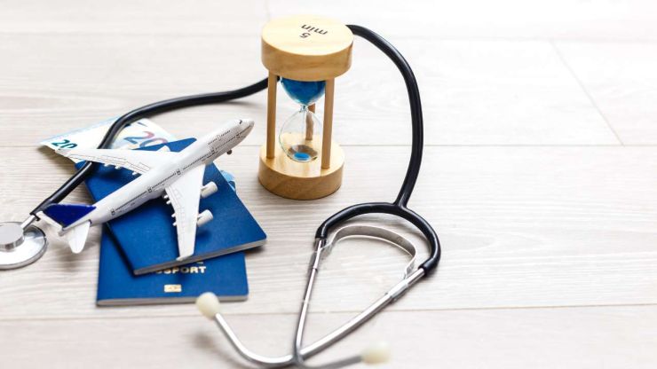 Uz galda lidmašīna, dokumenti, smilšu pulkstenis, stetoskops - ceļojuma apdrošināšanas polise iekļauj šos zaudējumu riskus