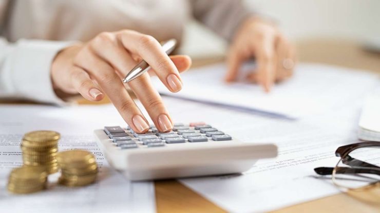 Sieviete uz kalkulatora rēķina nepieciešamos apmaksai nodokļus, nemaz nedomājot par to, kāpēc jāmaksā šie nodokļi