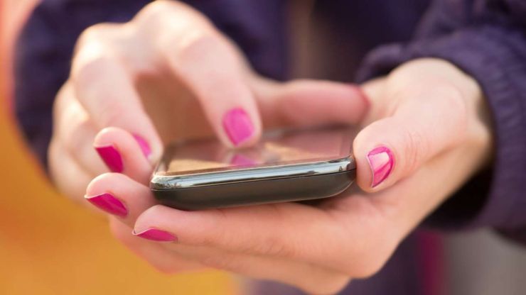 Женщина через телефон ищет варианты СМС кредитов, потому что нуждается в срочном финансовом решении