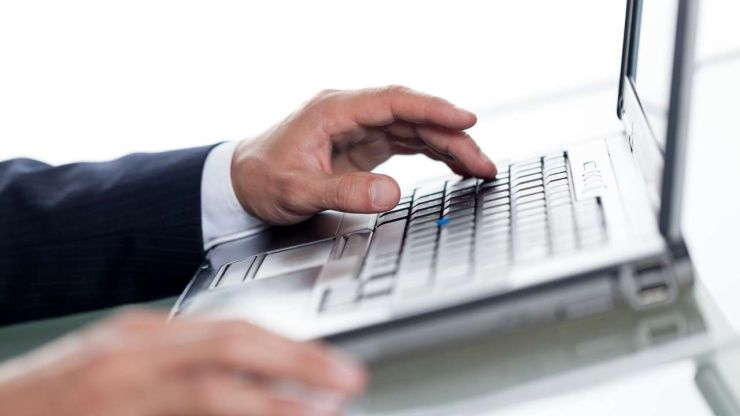 Vīrietis datorā meklē, vai kādā kredītiestāde izsniegs kredītu cilvēkam ar parādiem