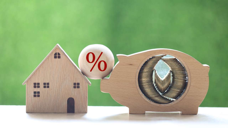 Koka māja un krājkase ar procenta zīmi, ilustrējot hipotēku un mainīgo procentu likmi