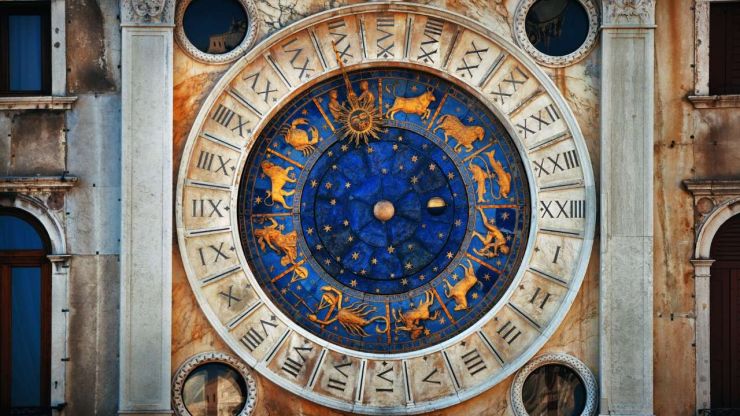 Астрологический круг и римские цифры на фасаде здания, как символ финансового гороскопа на апрель 2023 года