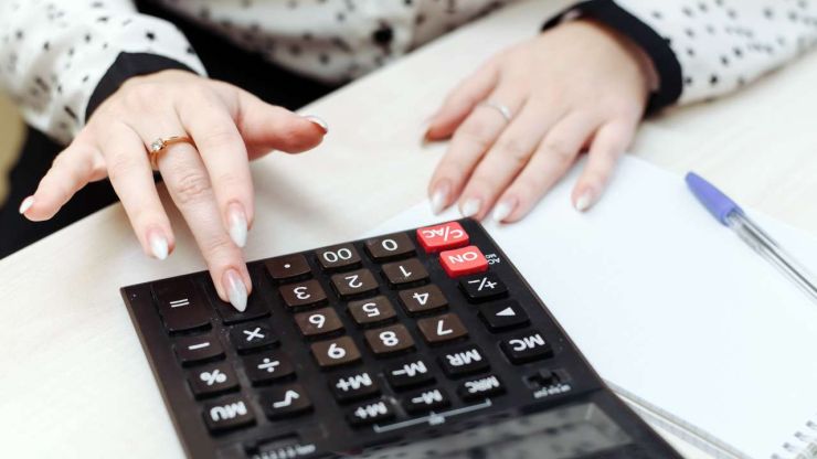 Sieviete veido budžetu, aprēķinot uz kalkulatora ģimenes ienākumus un izdevumus