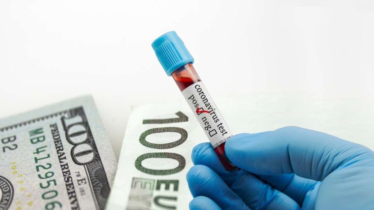 Ārsts rokā tur asins analīzi uz Covid un fona 100 euro un 100 dolāri – pandēmija pielika roku finanšu krīzei