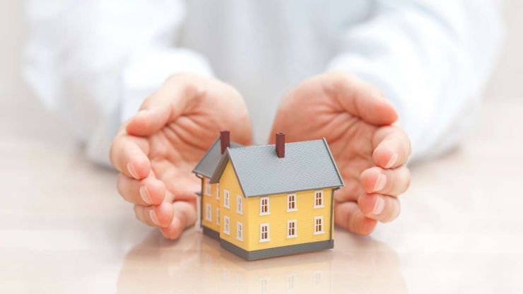 Руки обволакивают домик, как бы его защищая – это главная работа страхования кредита