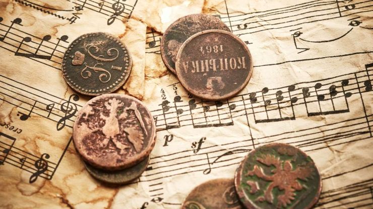 Senlaicīgas monētas uz papīra ar notīm – metāla nauda