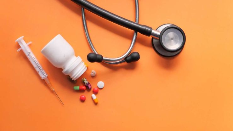 Stetoskops, bundžiņa ar dažādām krāsainām tabletēm un šļirce: sekojiet līdzi veselībai, lai ietaupītu uz medicīnas izdevumiem