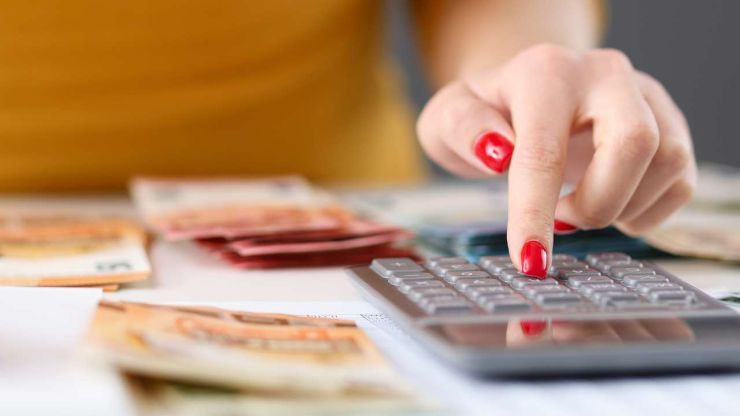 Sieviete uz kalkulatora skaita ienākumus un izdevumus, jo plāno veidot budžetu