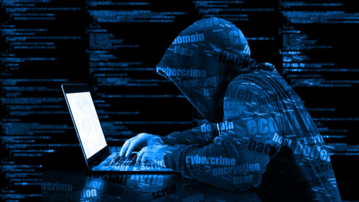 Силуэт хакера за ноутбуком на фоне цифровых кодов, ассоциирующийся с киберугрозами и кибербезопасности