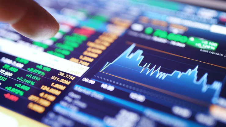 Палец указывает на экран устройства с графиками и данными валютных и финансовых рынков