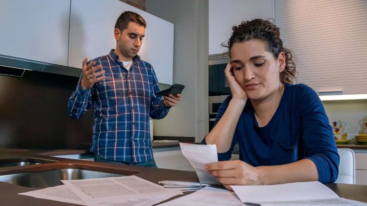 Sieviete sēž un skatās rēķinus, bet vīrietis rēķina kalkulatorā un saprot, ka neiztikt bez kredīta, ko varētu saņemt bez darba vietas