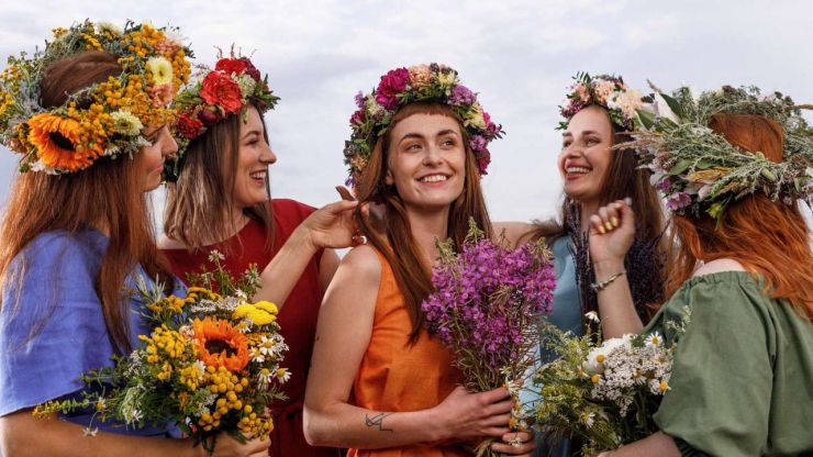 Пять девушек с цветочными венками и букетами полевых цветов на праздновании Лиго и Янова дня в 2023 году