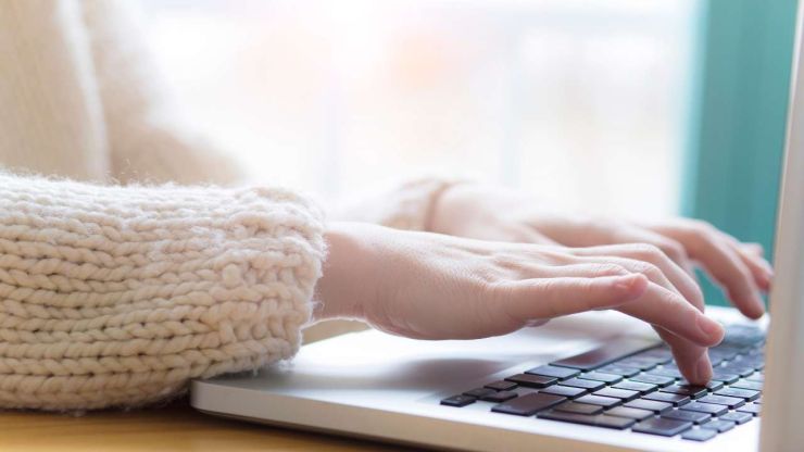 Девушка сидит за ноутбуком, при помощи которого ищет, где взять деньги в долг в интернете