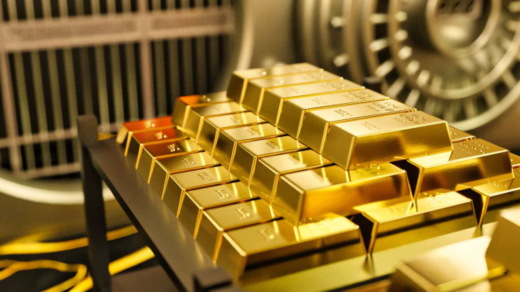 Золотые слитки на фоне банковского сейфа как способ выгодного вложения сбережений
