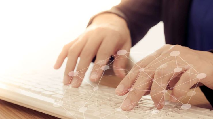 Человек пишет, используя белую клавиатуру, а на переднем фоне видно нейросети цифровой экономики
