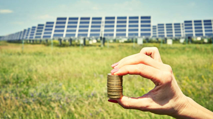 Солнечные батареи и монеты в женской руке – инвестиции в солнечную энергию как концепт энергосбережения