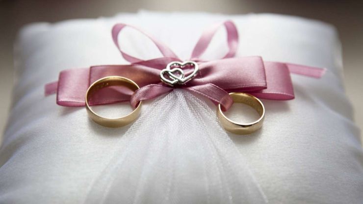 Ar rozā lentīti sasietie jaunlaulāto gredzeni, kas nopirkti pateicoties kāzu kredītam
