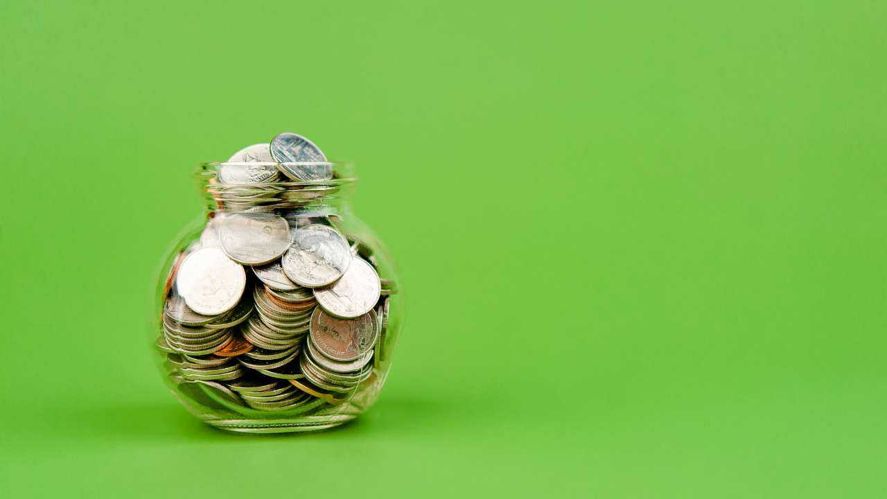На зеленом фоне маленькая баночка полная монет, потому что финансовые техники включают также сбережения