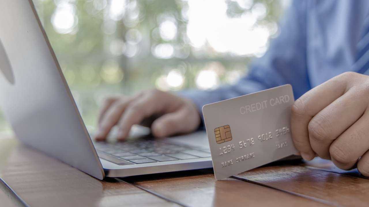 Мужчина хочет на свою карту быстро получить кредит, поэтому в ноутбуке заполнят онлайн заявку