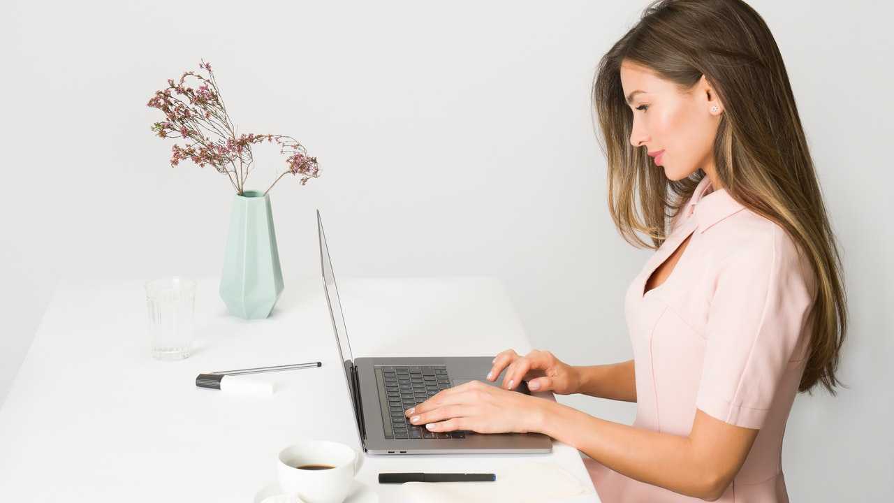 Sieviete laptopā veic elektronisku pārskaitījumu, izmantojot SWIFT kodu