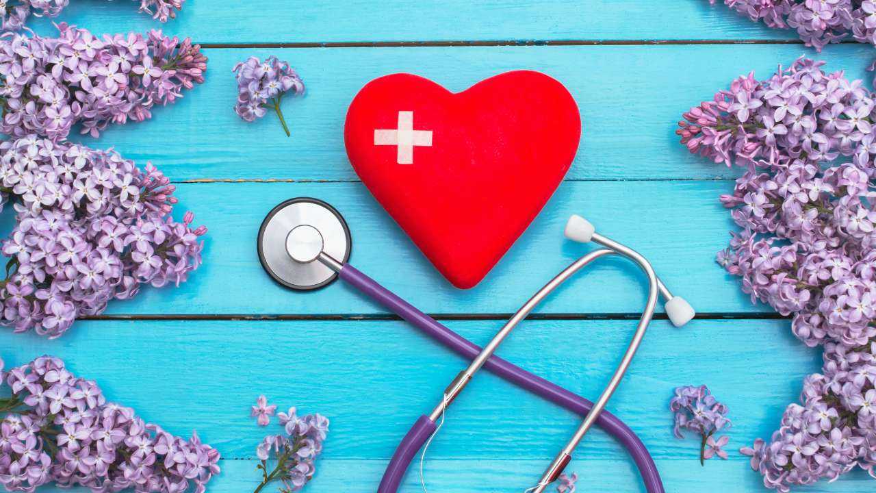 Uz zila koka galda sirds ar plāksteriem, stetoskops un ceriņi, jo laba veselība ļauj ietaupīt uz medicīnas izdevumiem