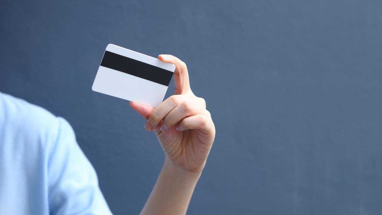 Заемщик держит в руке банковскую карту, на которую переведены полученные деньги до зарплаты