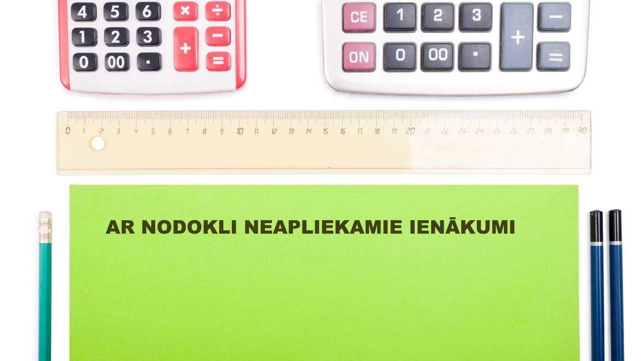 Uz galda nolikti divi kalkulatori, lineāls, zīmuļi un zaļā lapa ar uzrakstu “ar nodokli neapliekamie ienākumi”