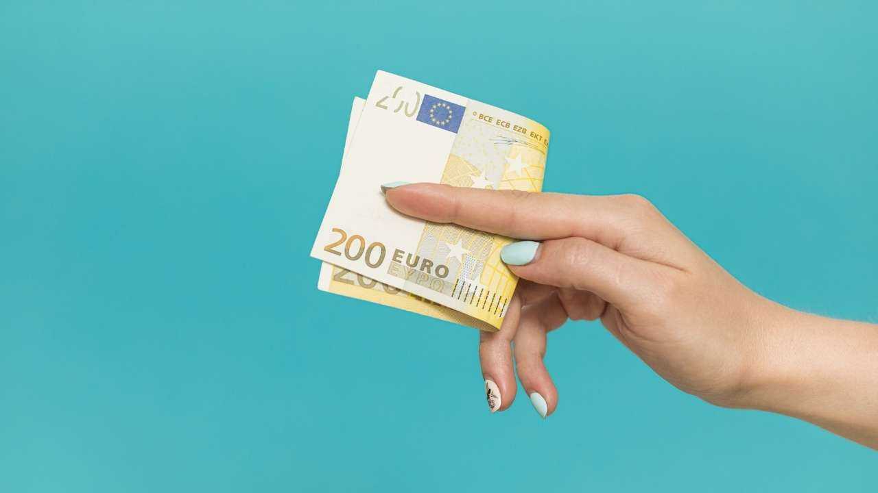 Девушка держит в руке аванс – 200 евро