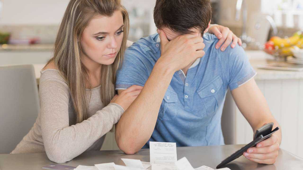 Жена ободряющее приобняла мужа, который расстроен из-за счетов и расходов, потому что в их паре есть финансовая эмпатия