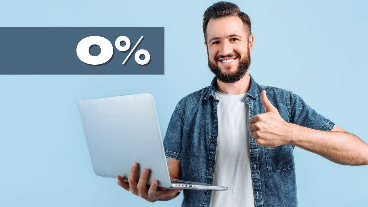 Мужчина держит ноутбук и показывает «класс», так как нашел хорошее предложение беспроцентного кредита
